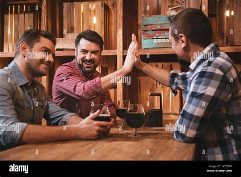 Handsome cheerful friends giving high five Stock Photo - Alamy