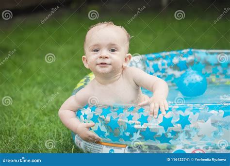 Portrait of Cute Baby Boy Swimming in Inflatable Pool at House Backyard and Looking in Camera ...
