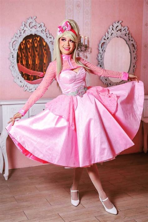 a barbie doll is posing in a pink dress