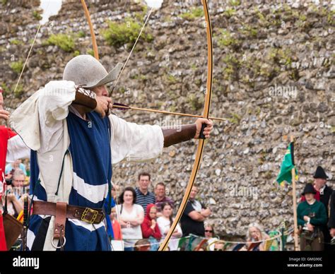 A medieval reenactor displays longbow archery techniques within the ...