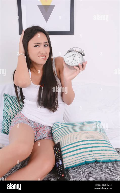 Beautiful young woman with alarm clock. Indoors Stock Photo - Alamy