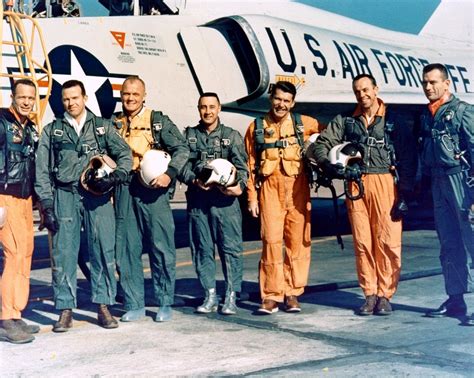 a group of men standing next to each other in front of an airplane