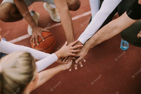 Premium Photo | Top view of basketball team holding hands over court