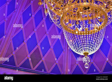 A golden crystal chandelier hangs from the ceiling of a blue and pink princess room Stock Photo ...