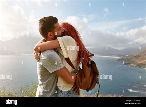 Portrait of a happy young couple enjoying a romantic embrace outdoors. Young man hugging his ...