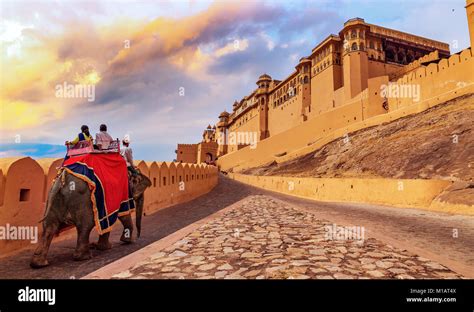 Tourists enjoy elephant ride at sunset at the historic Amer Fort (Amber Fort) Jaipur Rajasthan ...