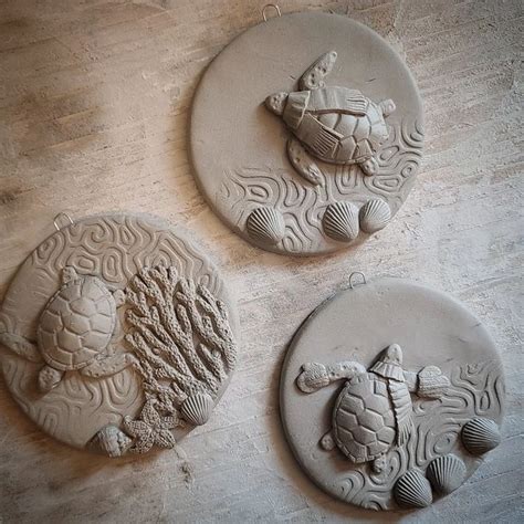 three clay plaques with sea turtles and seashells on them