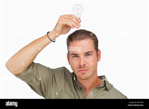 Man holding light bulb above his head Stock Photo - Alamy