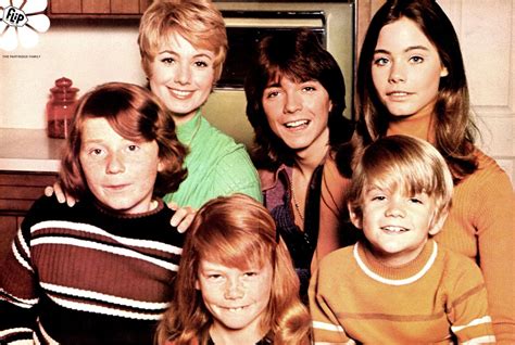 a group of people standing next to each other in front of a stove top oven