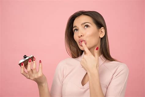 woman, eating, cupcake, standing, pink, background, inside, room | Piqsels