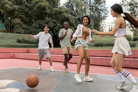 Delighted multiethnic friends playing basketball in park · Free Stock Photo