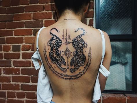 A girl with Twin Tigers Sak Yant [Yantra tattoo] Muay Thai tattoo on ...