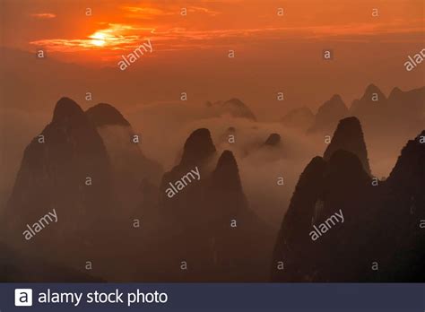 Dramatic sunrise over fog shrouded limestone peaks of Guilin Stock ...