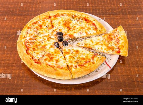 small margarita pizza slice with lots of mozzarella cheese with black olives, tomato and oregano ...