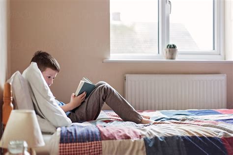 "Boy Reading A Book While Lying On A Bed" by Stocksy Contributor ...