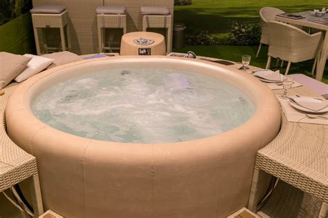 Round whirlpool with beige leather cover and matching side tables made of rattan - Creative ...