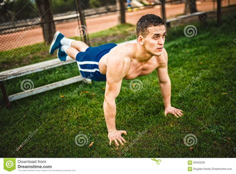 Athletic Man during Workout in Park. Fitness Personal Trainer Doing Pushups on Grass. Cross-fit ...