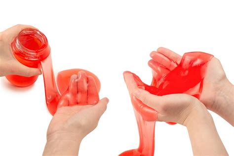 Premium Photo | Red slime toy in woman hand isolated on white