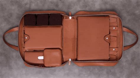 the inside of a brown leather briefcase with two compartments on each side and one compartment open