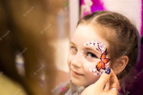 Premium Photo | Childrens makeup face paint drawings girls face painting little girl having face ...