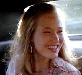 a smiling woman sitting in the back seat of a car