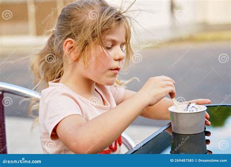 Little Adorable Preschool Girl Eating Ice Cream Sundae in Cup on Sunny Summer Day. Happy Toddler ...