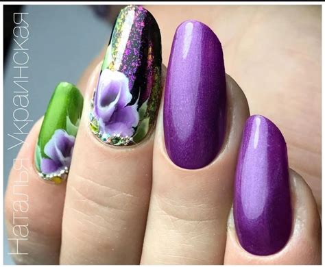 a woman's hand with purple and green nail polishes on her nails,