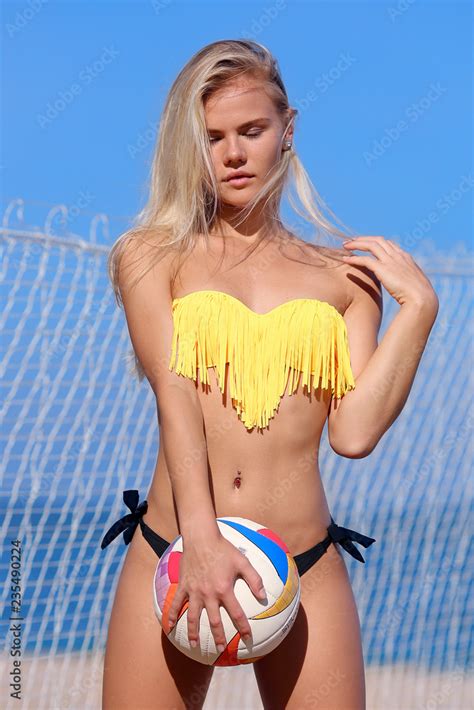 Sexy young woman with a ball. Beach volleyball player, playing summer. Stock Photo | Adobe Stock