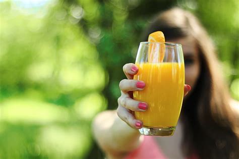 Royalty-Free photo: Woman holding glass of juice | PickPik
