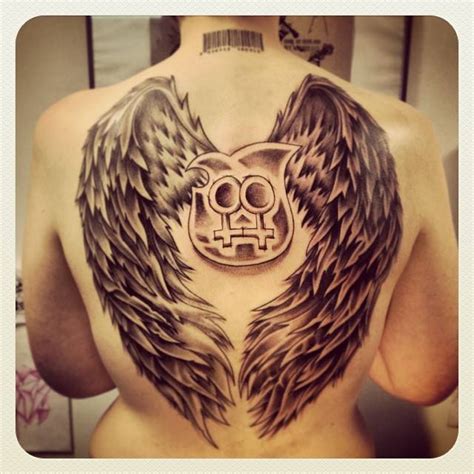 Black and grey wings tattoo on the back.