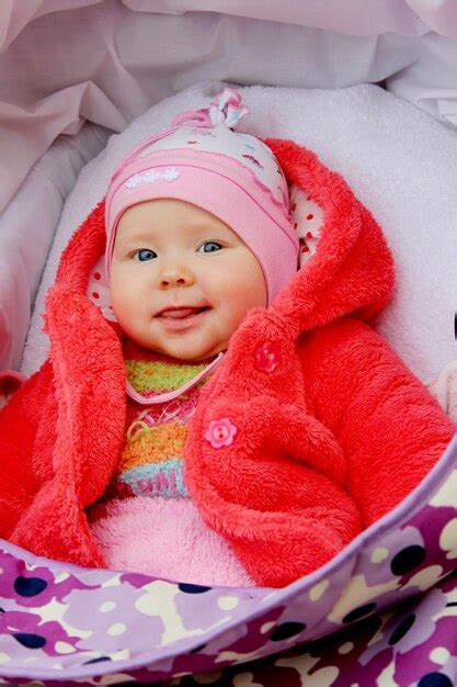 Premium Photo | Little baby in red suit smiling in perambulator happy ...