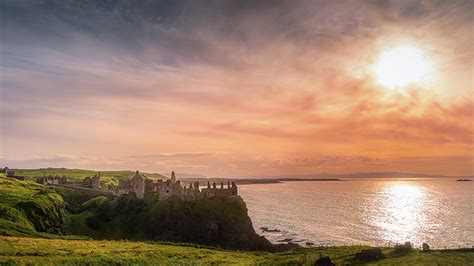 Sunset at ruins of Dunluce Castle Photograph by Dawid Kalisinski - Pixels