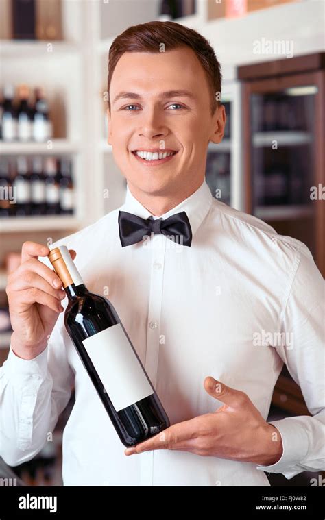 Professional sommelier holding wine bottle Stock Photo - Alamy