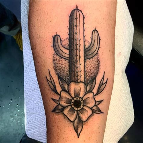 a cactus and flower tattoo design on the right leg, done by an expert in body art