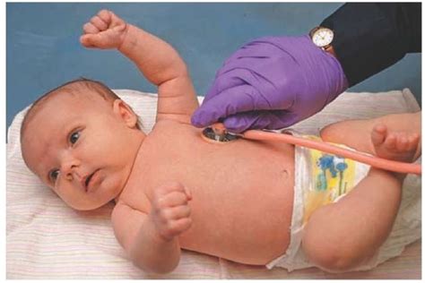 Paramedic assessing an apical pulse in a child. The stethoscope is held ...