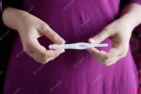Premium Photo | Women hand holding pregnancy test kit on a wood desk