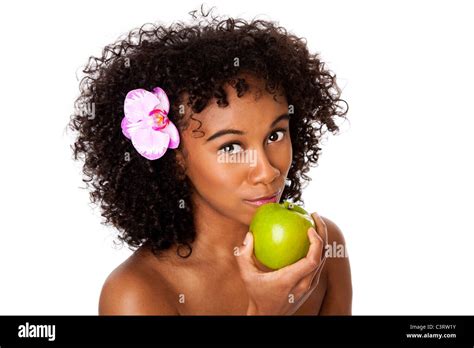 Beautiful happy woman with orchid flower in curly hair eating healthy green apple, isolated ...