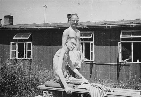 Two emaciated survivors of the Buchenwald concentration camp pose outside the hospital barracks ...