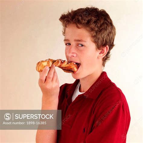 Child eating croissant - SuperStock