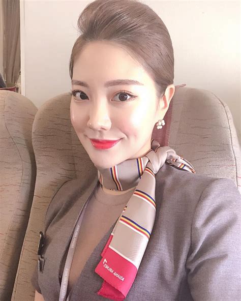 a woman sitting on an airplane wearing a neck tie