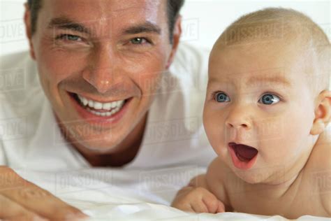 Father and baby laughing together, portrait - Stock Photo - Dissolve