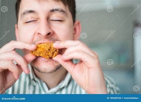 Man Eat Spicy Chicken. Hot Chicken Wings, Guy Bites Off Spicy Chicken with Eyes Closed Stock ...