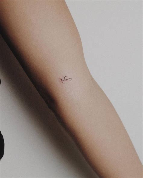Minimalist letter "L" tattoo on the inner arm.