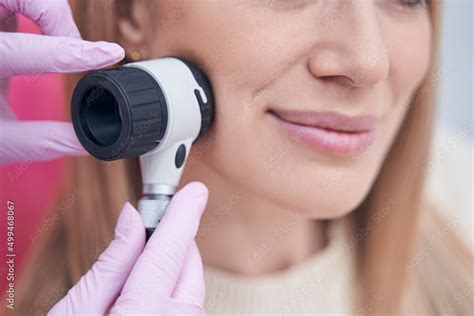 Dermatologist using dermoscopy device during patient skin check Stock Photo | Adobe Stock