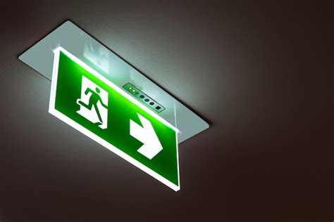 Premium Photo | Green emergency exit sign showing the way to escape.