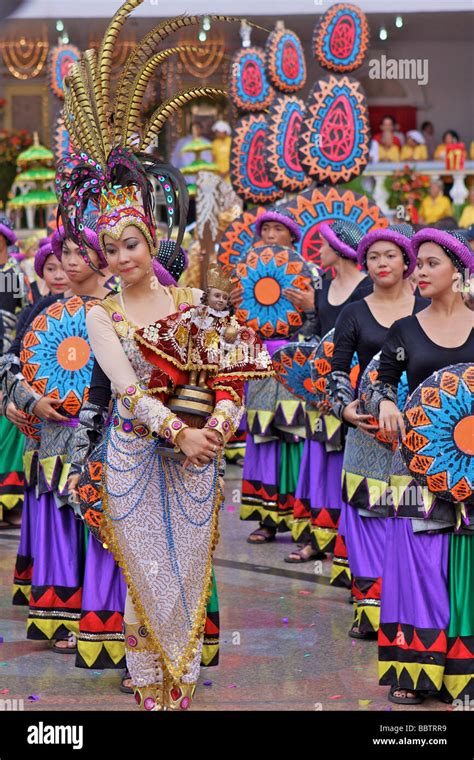 woman with sinulog costume and a Santo Niño doll in the sinulog parade ...