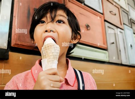 Southeast Asian boy enjoy eating vanilla ice cream cone at mall Stock Photo - Alamy