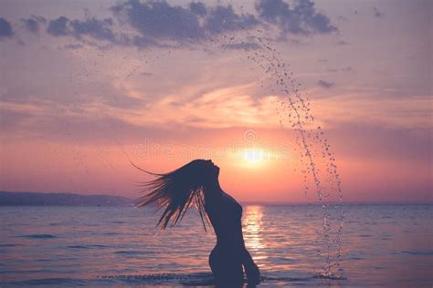Silhouette of Female Splashing Water with Her Hair at Sunset Over Sea Stock Image - Image of ...