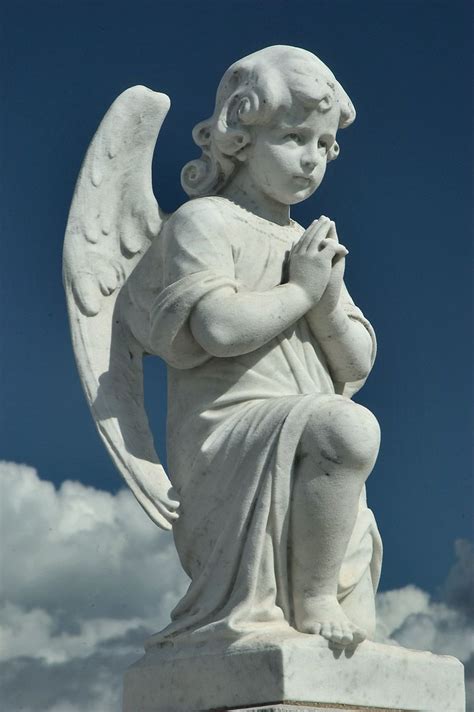 A young angel (cherub) sitting on a cloud in Saint Louis Cemetery No. 3. asergeev.com Cemetery ...