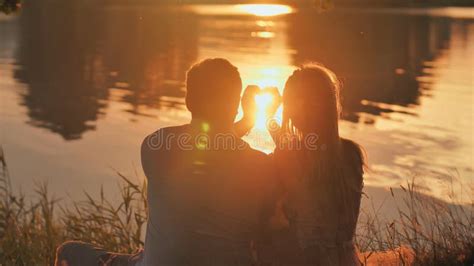 Silhouette of a Young Couple Making a Heart Shape from Their Hands. Stock Photo - Image of ...